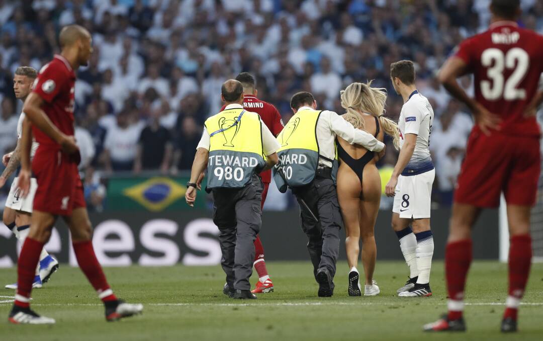 SHOW STOPPER: Pitch invader Kinsey Wolanski is escorted from the field during the Champions League final. Surely the NRL can put her talents to good use. Picture: AAP 