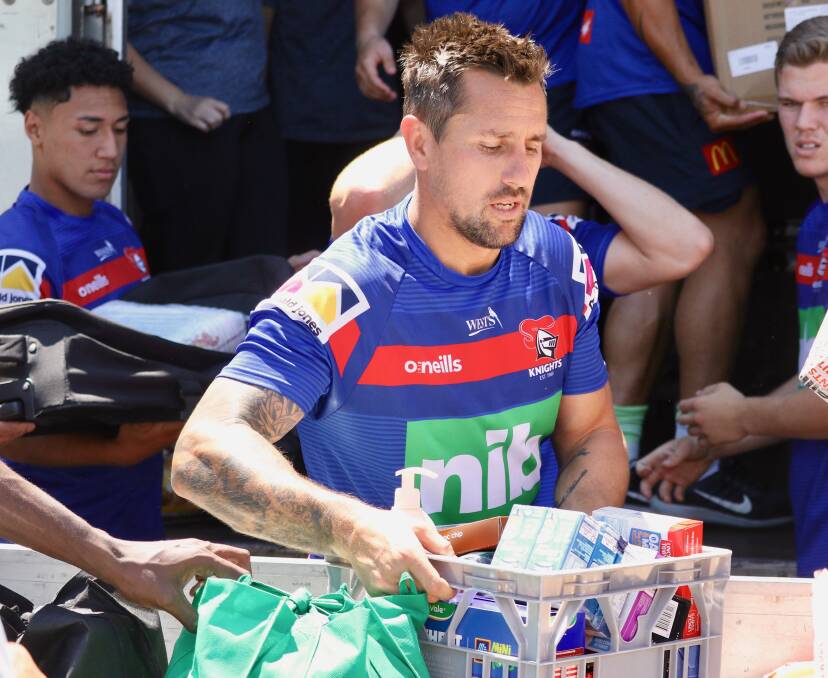 LENDING A HAND: Mitchell Pearce with a crate of provisions.