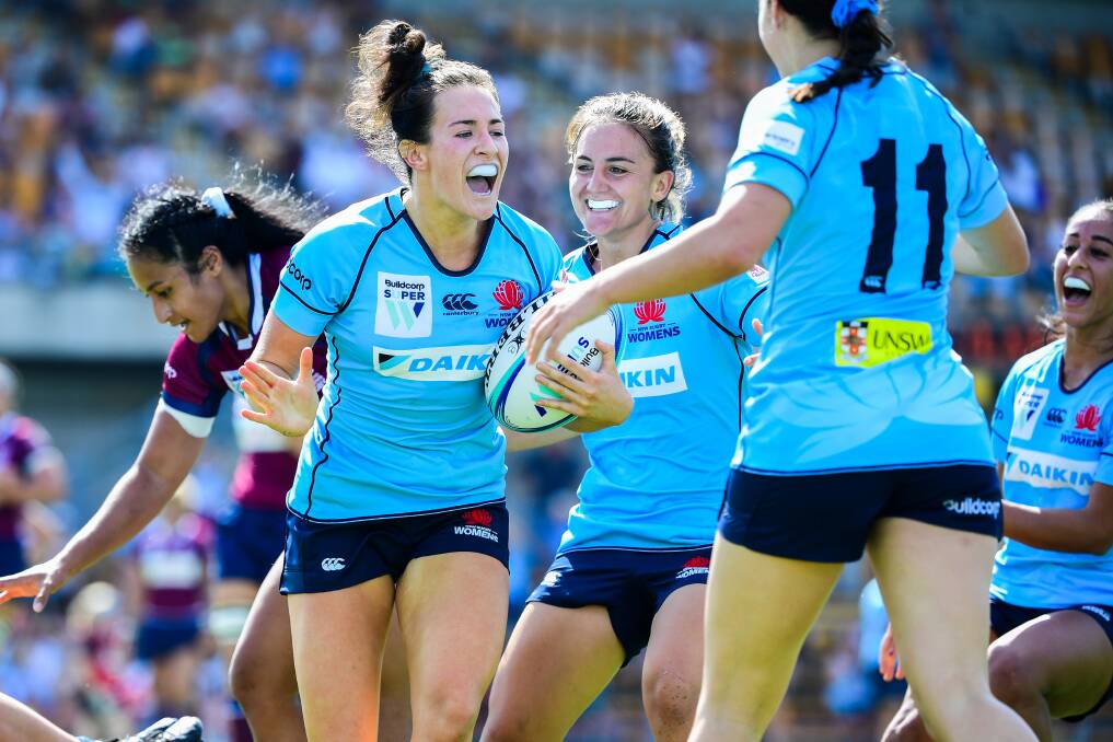 IN CONTENTION: Maya Stewart (left) is congratulated by Katrina Barker (centre) after scoring her first try for NSW in the Super W. Both players in the Wallaroos train-on squad. Picture: AAP