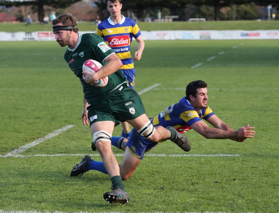 Merewether No.8 Lachy Milton beats an attempted tackle by Hamilton centre Sam McNeil in the Greens' 28-26 win on Saturday.
Picture by Peter Lorimer