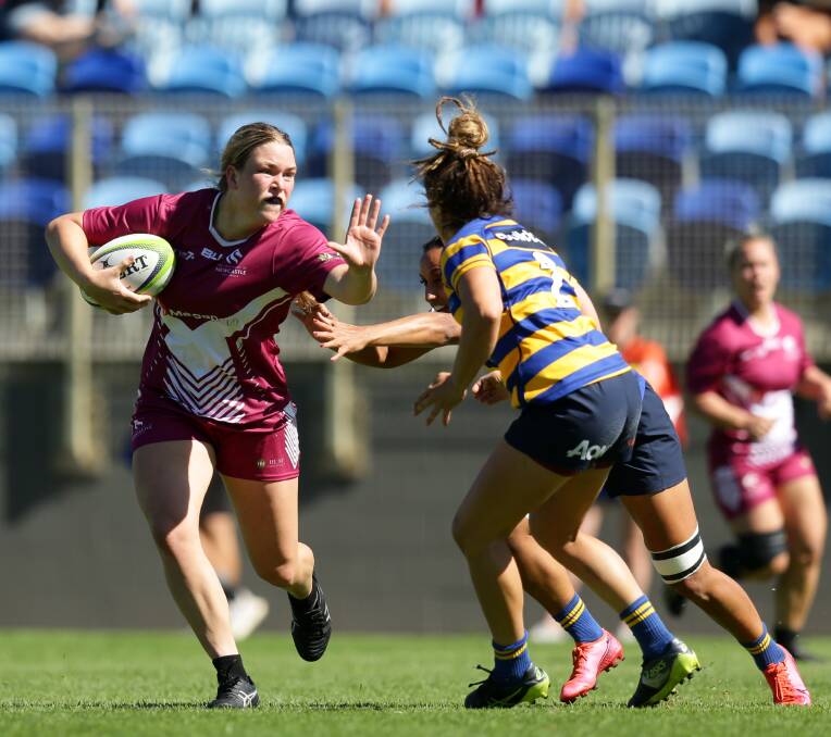 ON THE CHARGE: Kaitland Leaney fends off a Sydney Uni tackler during the National University Sevens Series tournament in Newcastle last year. Picture: Jonathan Carroll