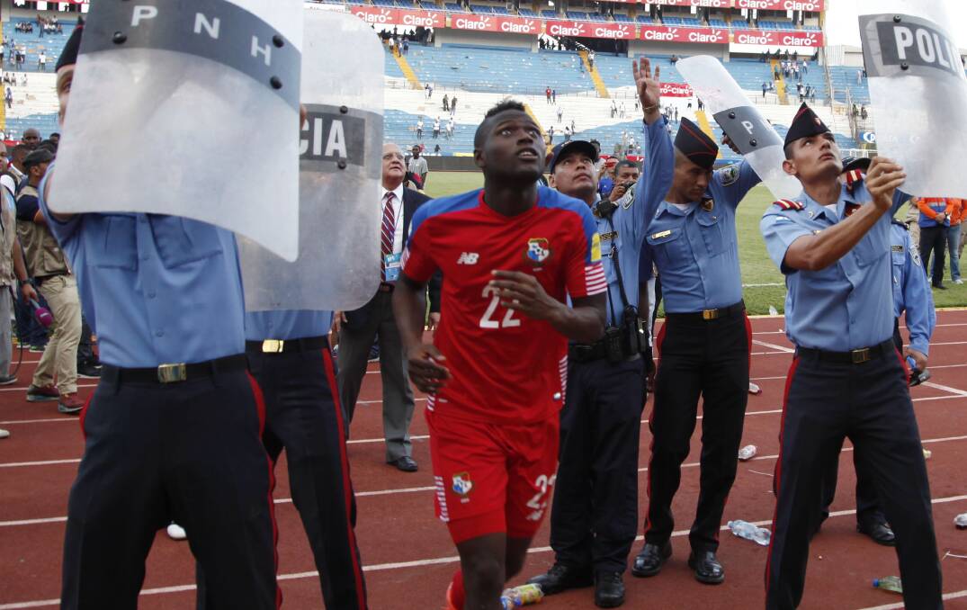 IN TRANSIT: Jets import Abdiel Arroyo is shielded by police after Panama's 1-0 win over Honduras in a 2018 World Cup qualifier. Picture: AP