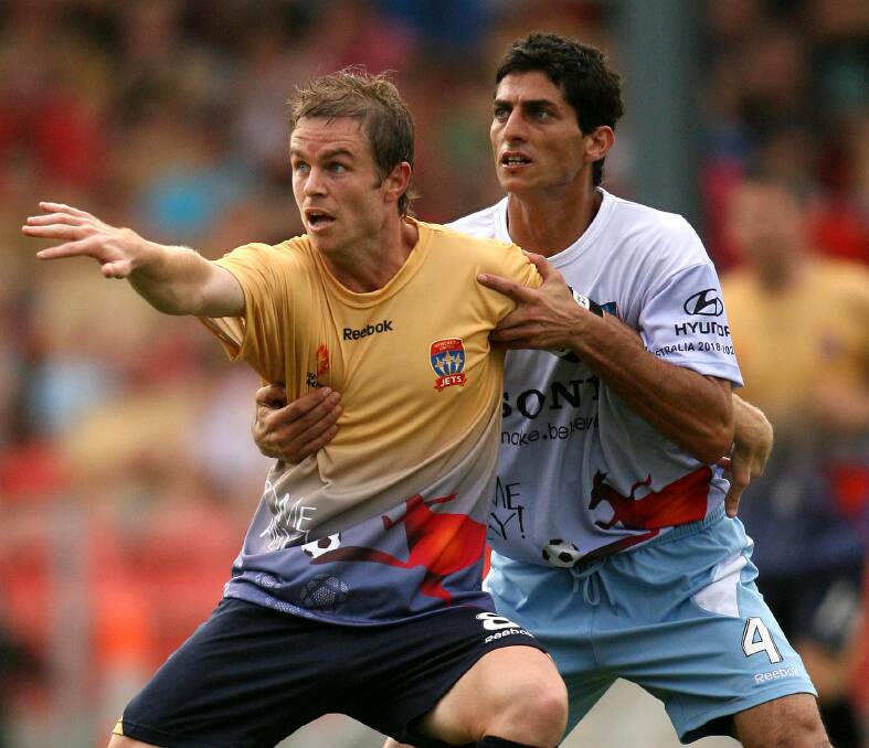 LEADER: Jets captain Matt Thompson holds off Sydney's Simon Colosimo. The Jets utility was the first player to reach 100 A-League games. Picture: Darren Pateman 