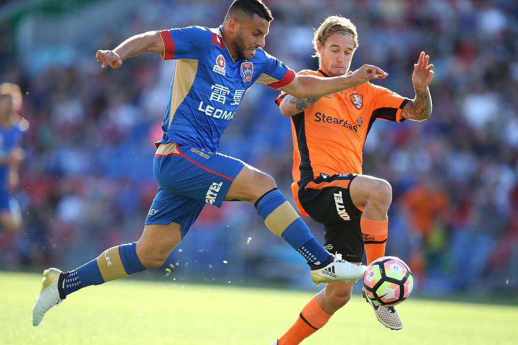 FLYING: Andrew Nabbout beats Brisbane midfielder Jacob Pepper to the ball in the Jets '4-0 win at McDonald Jones Stadium on Sunday. Picture: Getty Images