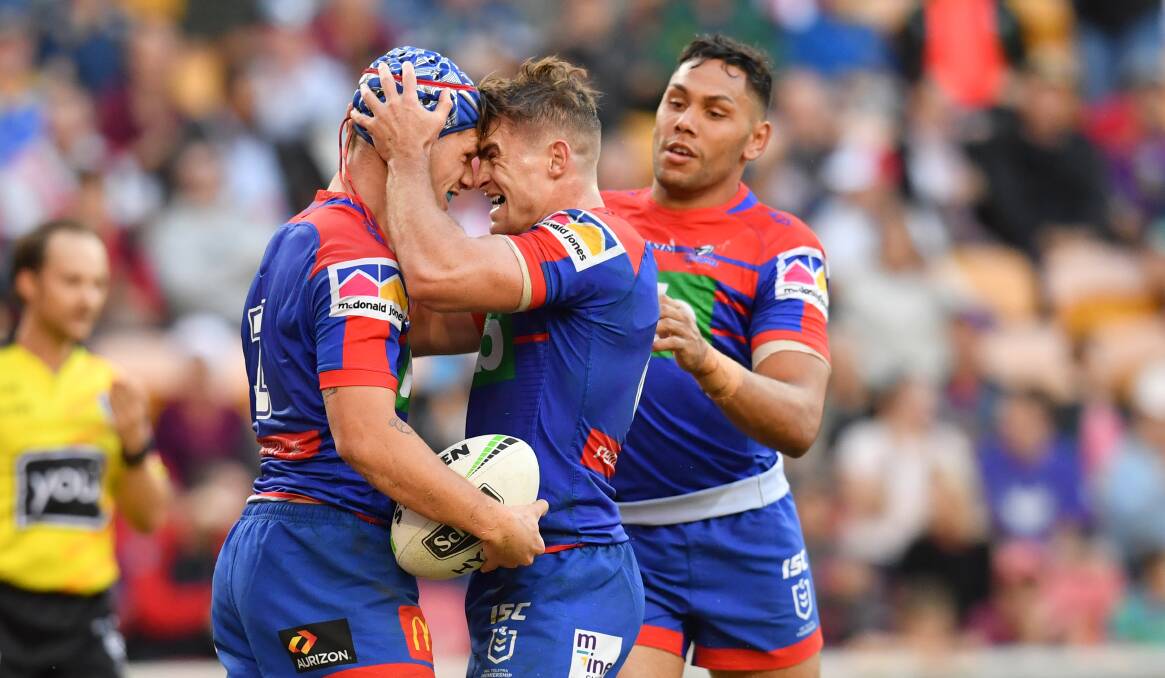 TRY-TIME: Kalyn Ponga is congratulated by Knights five-eighth and house mate Connor Watson after scoring a try to seal a 22-10 win over the Bulldogs. Picture: AAP