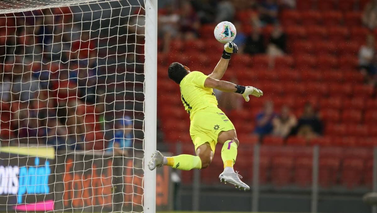 SAVIOUR: Roar keeper Jamie Young dives full stretch to his left to parry a shot away. Picture: Getty Images