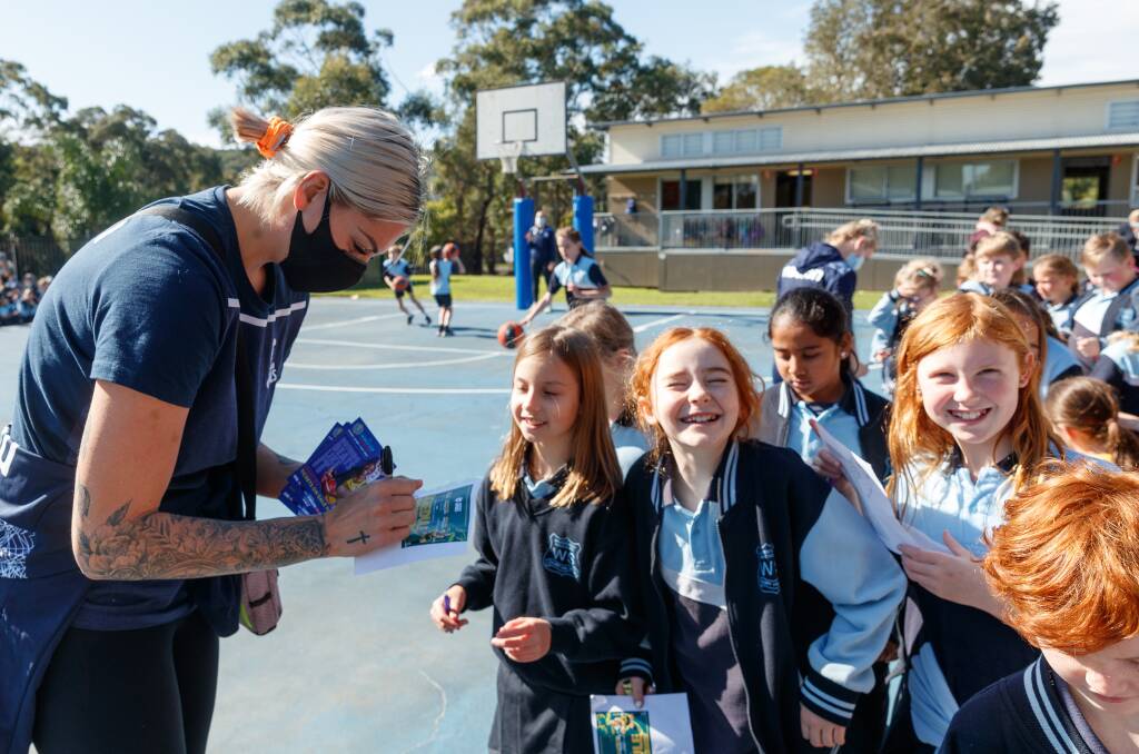 FOCUSED: Opals captain Cayla George signs autographs at Wallsend South Public School on Monday. Picture: Max Mason-Hubers