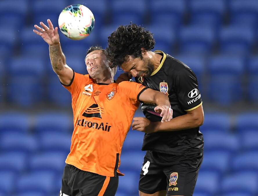 HEAD FIRST: Jets defender Nikolai Topor-Stanley competes against Scott McDonald for a header in the 1-0 loss to the Roar on Friday night. Picture: Getty Images