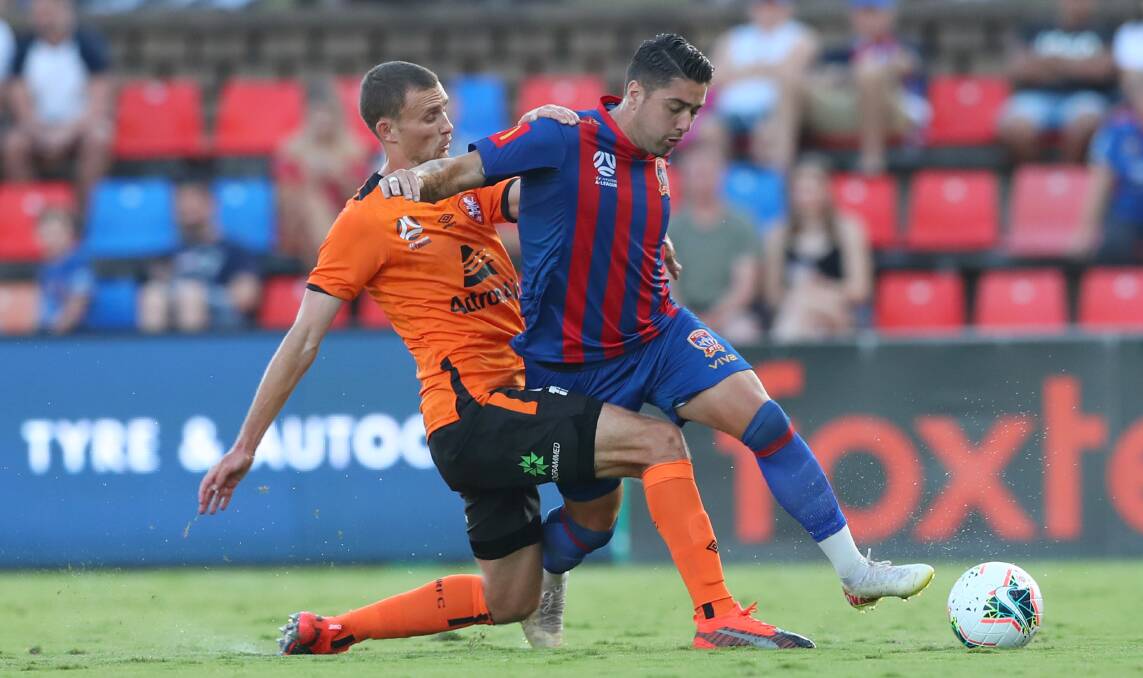 TOO STRONG: Dimi Petratos evades a tackle from Brisbane defender Daniel Bowles in the Jets 1-all draw with Brisbane Roar on Saturday night.