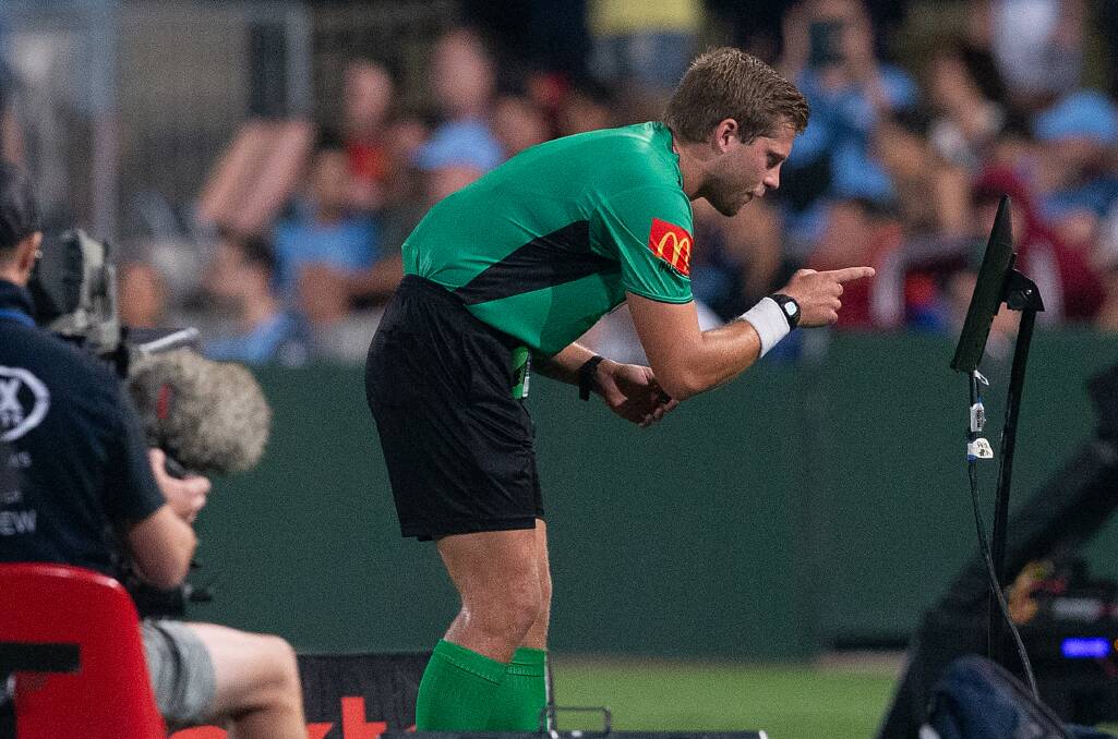 LETS GO TO THE VIDEO: Referee Alex Kings looks at an incident after it was pulled up by the VAR. Picture: AAP 