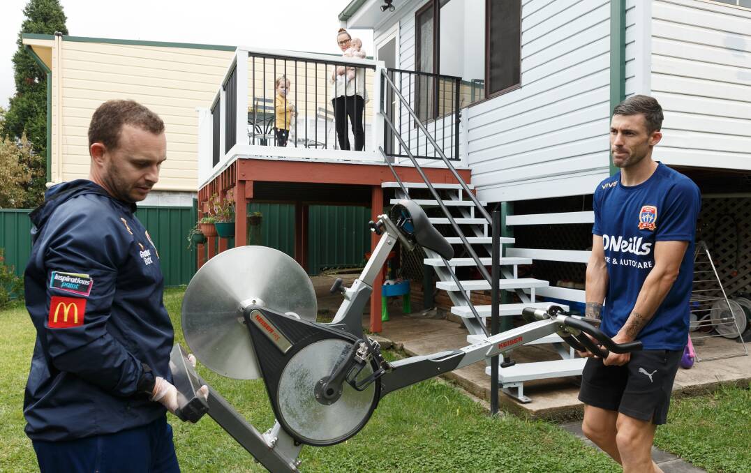 KEEPING UP: Jets physiotherapist Nathan Renwick helps Jason Hoffman unload an exercise bike to use during the club's hiatus. Picture: Max Mason-Hubers