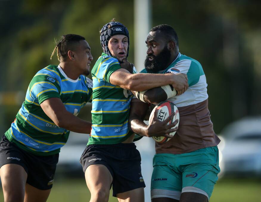  CENTRE OF ATTENTION: William Lewesi is meet by Uni Norths defenders Issy Vali and Miguel Fernandez in the Hunters Wildfires 29-20 to the Canberra side on Staurday. Picture: Marina Neil