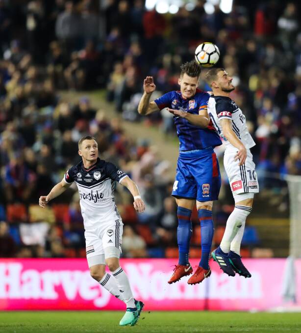 HEAD FIRST: Nigel Boogaard competes against Melbourne Victory attacker James Troisi for a header. Picture: AAP