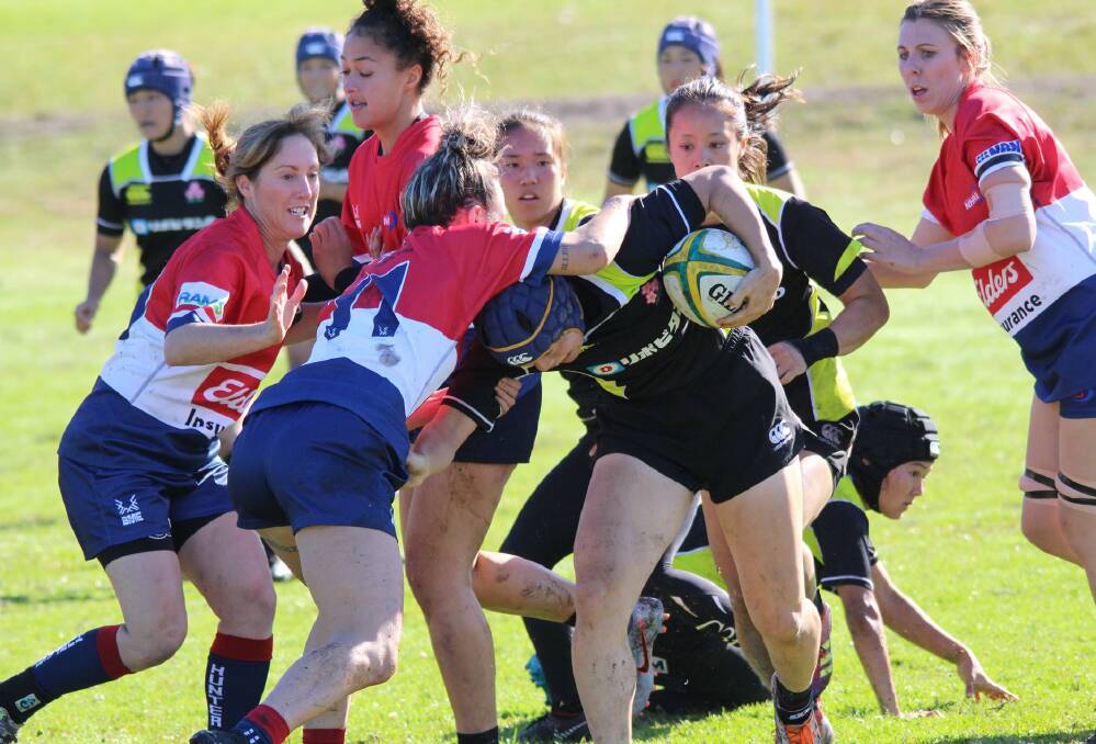 IN: Holly Smith (left) goes in to assist with a tackle for Hunter in an opposed session against Japan on Sunday. 