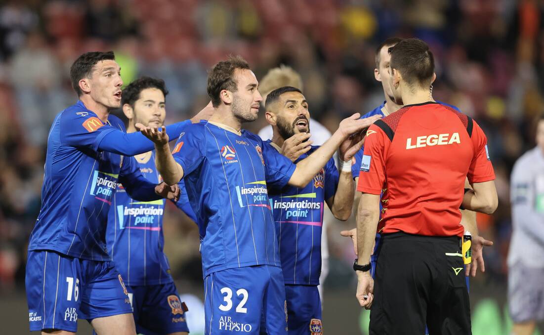 VAR FROM HAPPY: Bemused Newcastle Jets midfielder Angus Thurgate argues his case with referee Jonathan Barreiro. Picture: Ashley Federer (Getty Images)