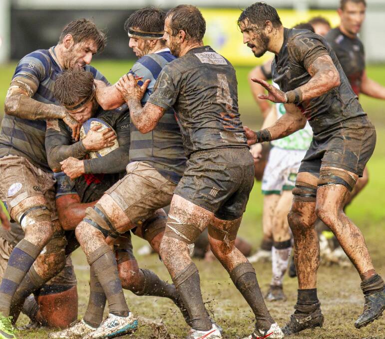 STUCK IN THE MUD: Maitland breakaway James Johnston is met by the Wanderers defence in the Blacks' 15-12 win at Passmore Oval. Pictures: Stewart Hazell.