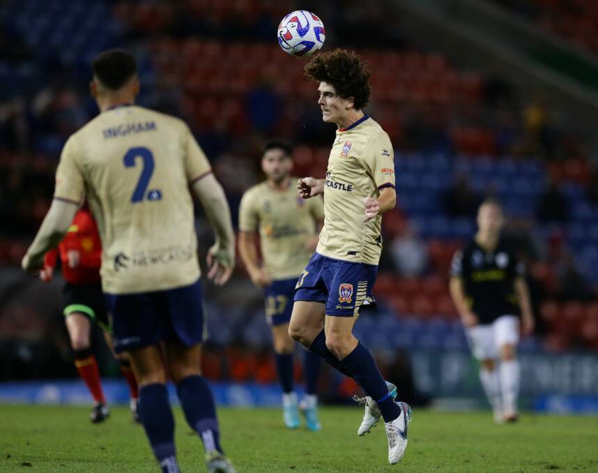 Newcastle Jets defender Mark Natta flies high to head a ball. Picture by Jonathan Carroll