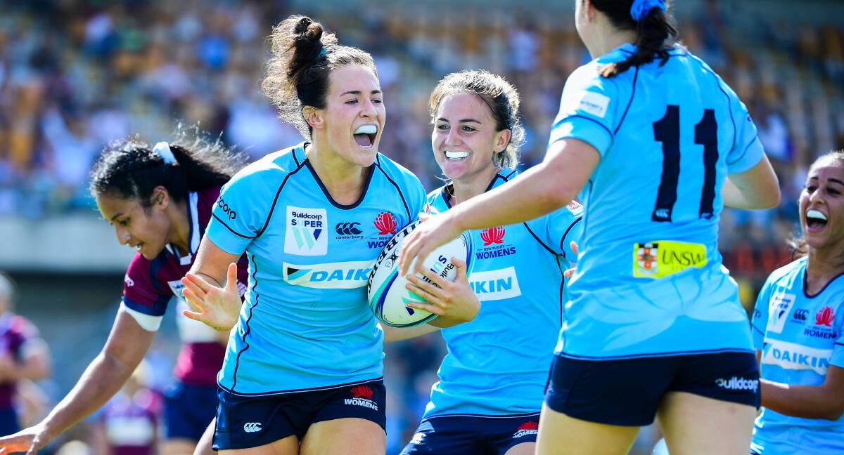 FLYER: Maya Stewart is congratulated by Waratahs teammates after crossing for a try against Queensland last year. Picture: Stuart Walmsley
