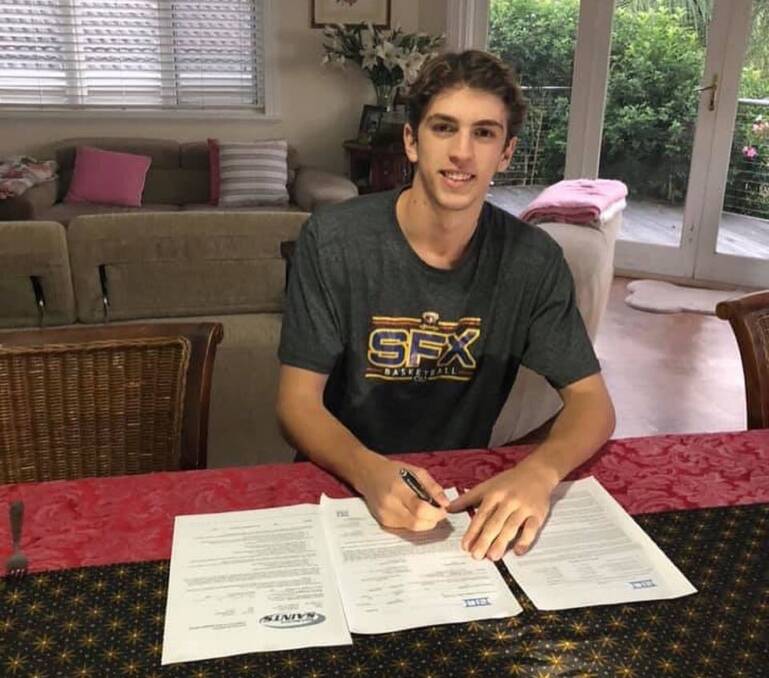 SIGNED AND DELIVERED: Alex Clinton filling out the paperwork to attend St Martin's University in the US. 