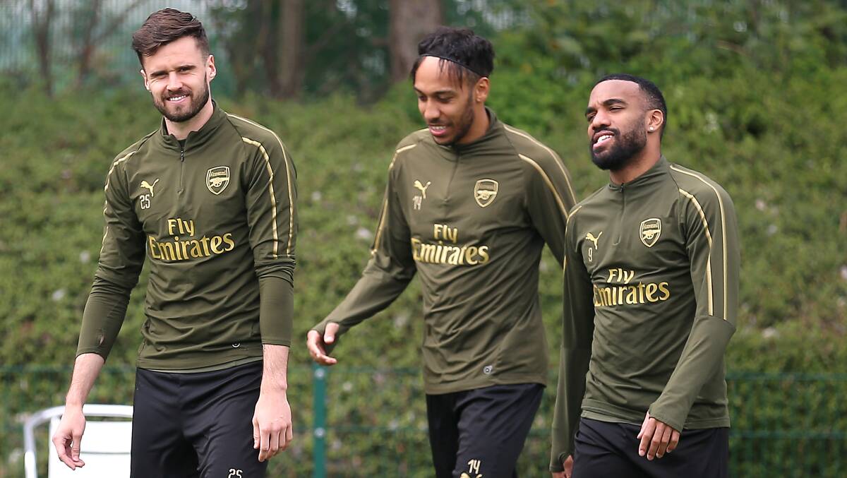 Carl Jenkinson (left), with Arsenal teammates Pierre-Emerick Aubameyang and Alexandre Lacazette in 2019 and below at Jets training last week. Pictures by Getty Images and Max Mason-Hubers