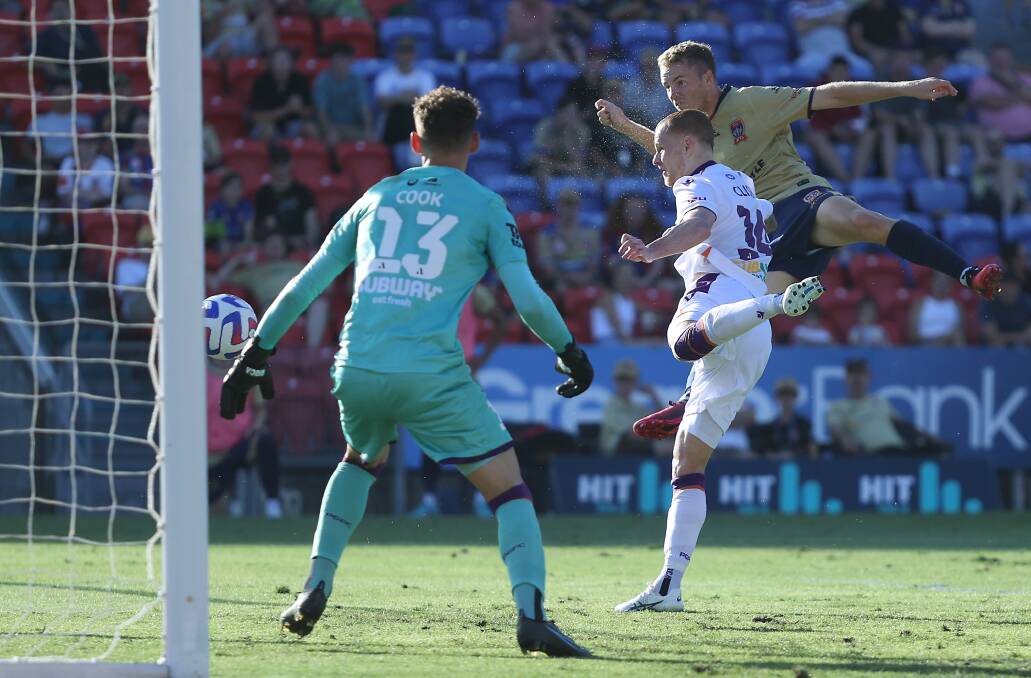 Winger Trent Buhagiar climbs high to head the ball into the net and put the Jets ahead in the 2-all draw with Perth Glory at McDonald Jones Stadium on Saturday night. Picture Getty Images