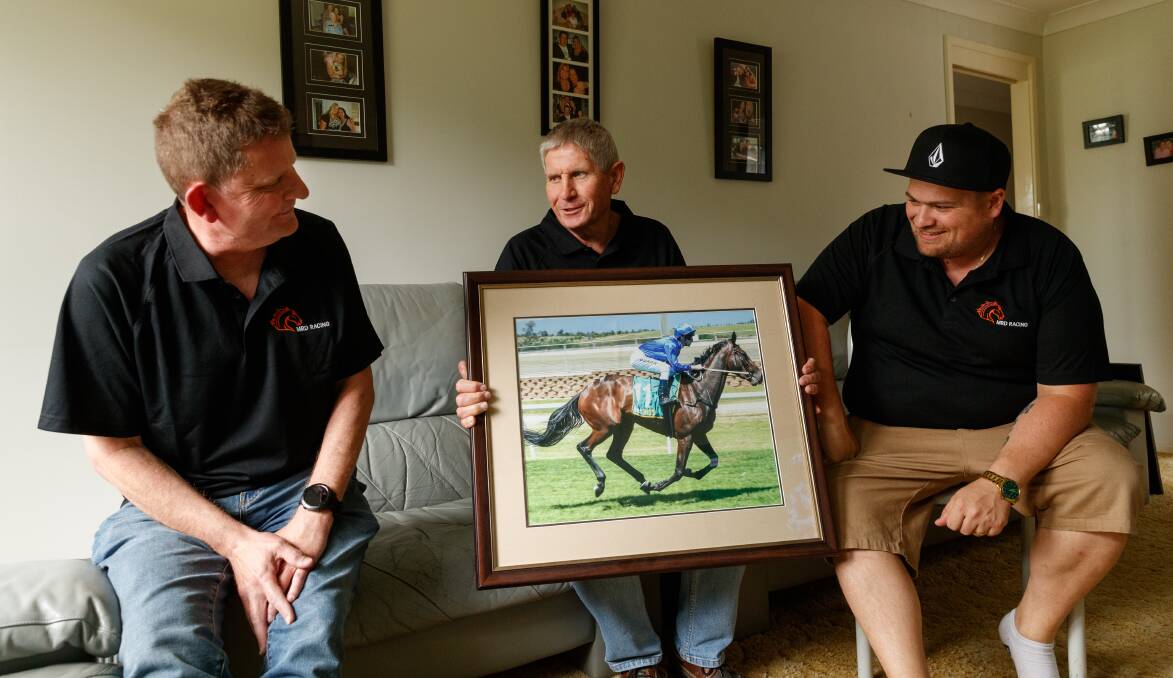 READY TO GO: Mark, Rudi and Daniel Medz with a picture of their Melbourne Cup runner Oceanex at Rudi's home at Barnsley, where they will watch the race from on Tuesday. Picture: Max Mason-Hubers