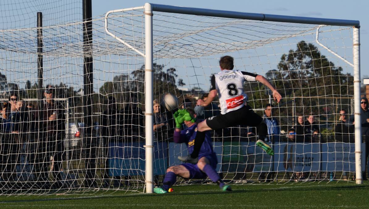WINNER: Matt Thompson puts Maitland into the grand final with an injury-time strike past Broadmeadow goalkeeper Paul Bitz on Sunday at Cooks Square Park. Picture: Michael Hartshorn