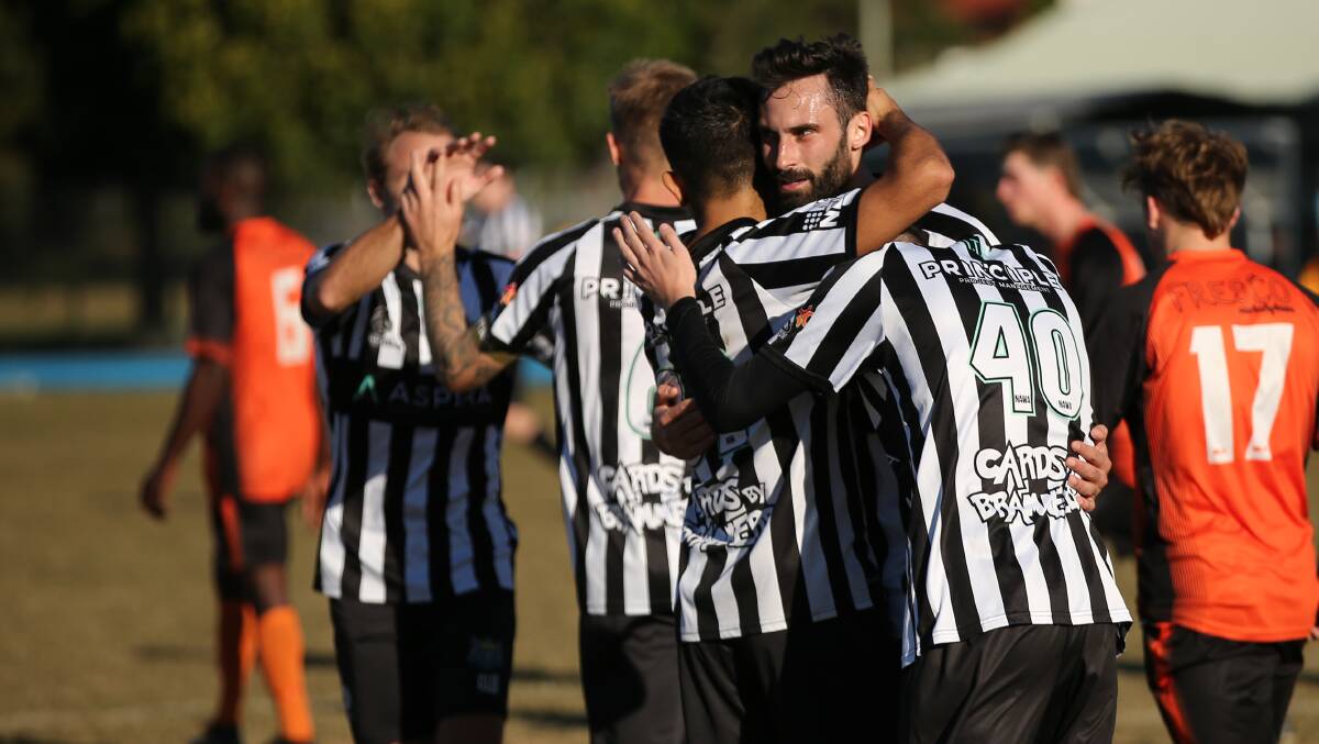 Daniel Yaxley, facing the camera, celebrates a goal for Cooks Hill last year in the Australia Cup. Yaxley is one of only a few regular first-graders back for the club this season. Picture by Max Mason-Hubers