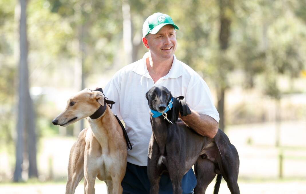Richmond Vale greyhound trainer Jason Mackay has two dogs in the upcoming Million Dollar Chase Final on Friday Night at Wentworth Park. Pictured with the dogs, Flying Bazza (brown) and Get It Gizmo (Black), at his home. Picture: Max Mason-Hubers MMH