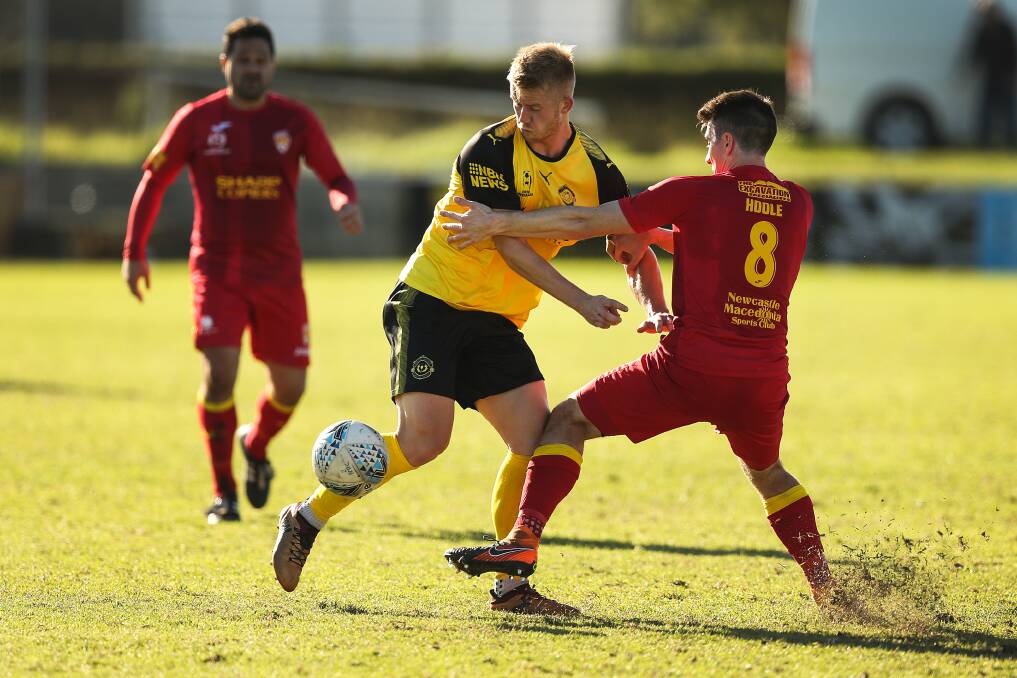 IN THE MIX: James Pendrigh competes for the ball with Broadmeadow's Matt Hoole at Magic Park on Sunday. Picture: Marina Neil
