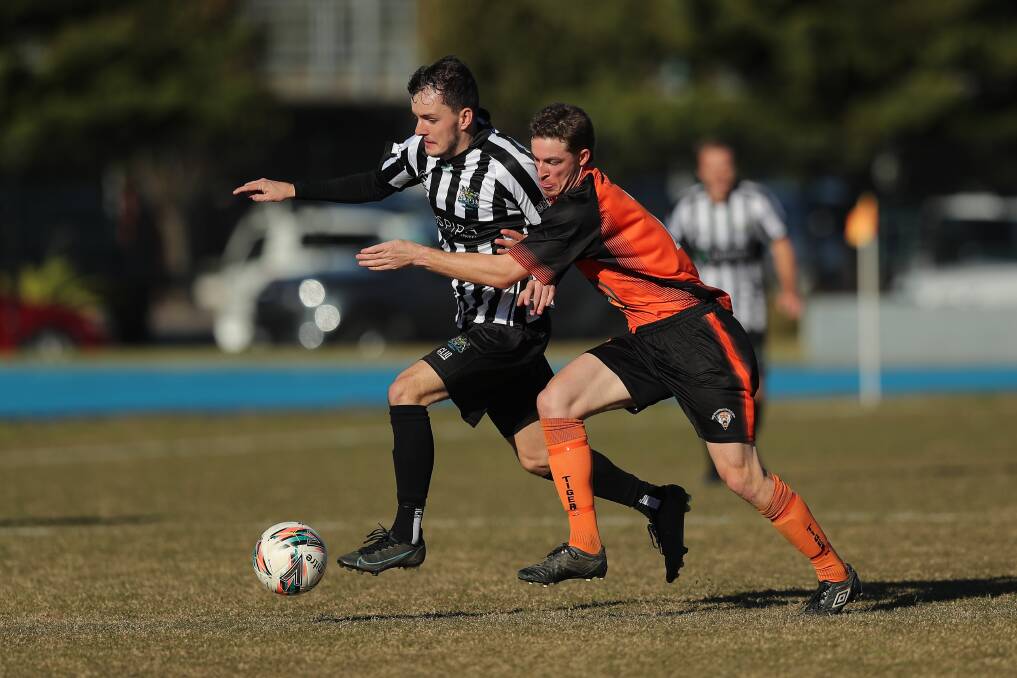 Cooks Hill's Josh Benson, left, in action against Coffs Coast in the Australia Cup. Picture by Max Mason-Hubers