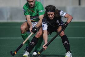 Wests' Angus Oakford and Maitland player Ryan Lance battle it out on Sunday at Newcastle International Hockey Centre. Picture by Marina Neil