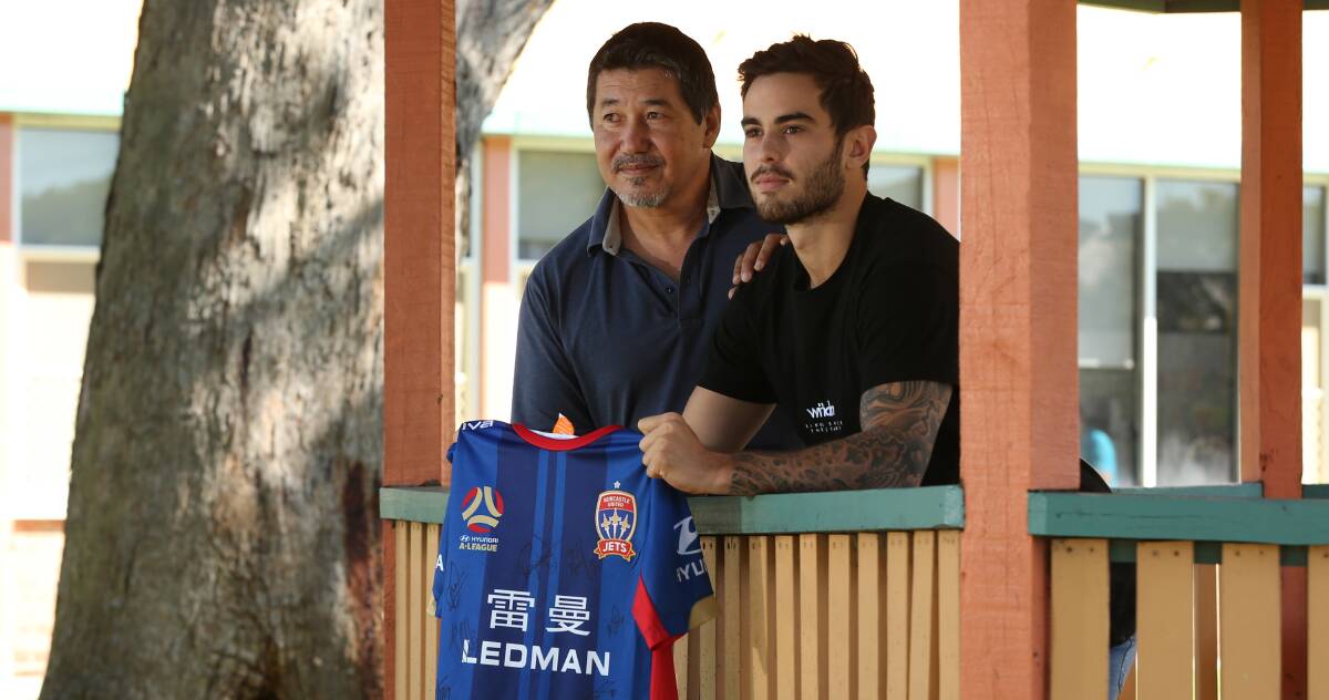 RECOVERING: Shayne and Cameron Holzheimer on Monday at Rankin Park Centre with the signed Newcastle Jets jersey from Men Of Football. Picture: Simone De Peak
