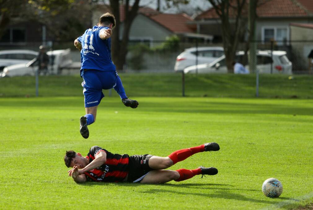 TAKE OFF: Newcastle Olympic goalscorer Jared Muller jumps over Edgeworth's Jordy Lennon at Darling Street Oval on Sunday. Picture: Jonathan Carroll