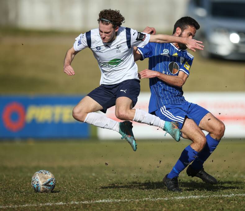 UNDER PRESSURE: Lake Macquarie's Tom Parkes, left, competes with Luke Rutledge during the 3-2 loss to Newcastle Olympic at Macquarie Field in June. Picture: Marina Neil