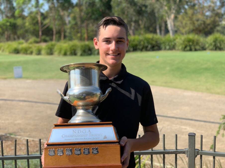 RISING STAR: Toronto teenager Jake Riley with the Newcastle district championship trophy on Saturday at Pacific Dunes. Picture: Supplied 