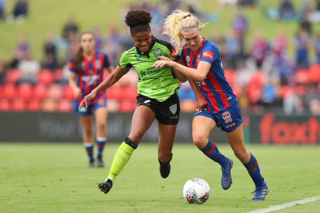 BATTLE: Canberra import Simone Charley and Newcastle's Teigan Collister compete for possession on Saturday at McDonald Jones Stadium. Picture: Getty Images