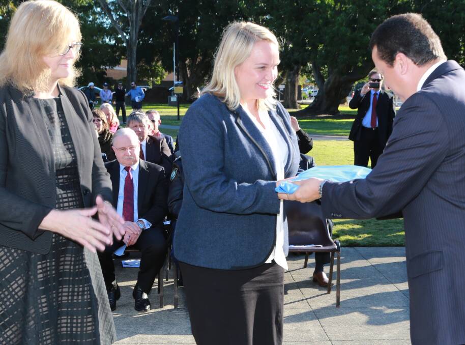 ENSIGN OF RESPECT: Alexander Mejia, of the UN, presents the flag to Lord Mayor Nuatali Nelmes, centre, and University of Newcastle Vice-Chancellor Caroline McMillen.