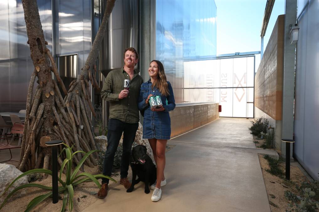 FRESHLY TAPPED: Modus Operandi co-founders Grant and Jaz Wearin with their dog Stout inside the new Merewether brewpub. Picture: Simone De Peak