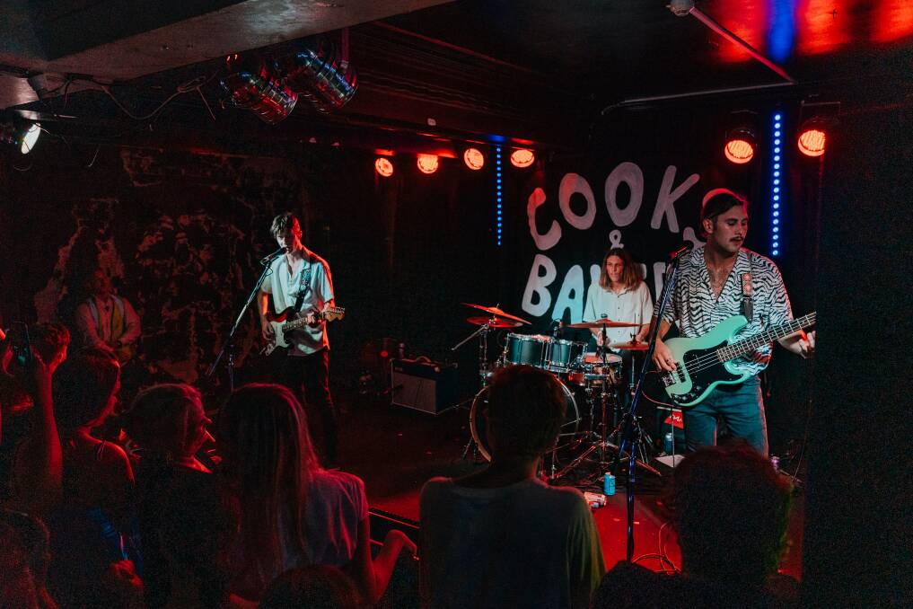 KICKING GOALS: Cooks & Bakers' Campbell Ross, from left, Finn Ellem and Nathaniel Duggan performing on stage at their sold-out Cambridge Hotel warehouse show last month. 