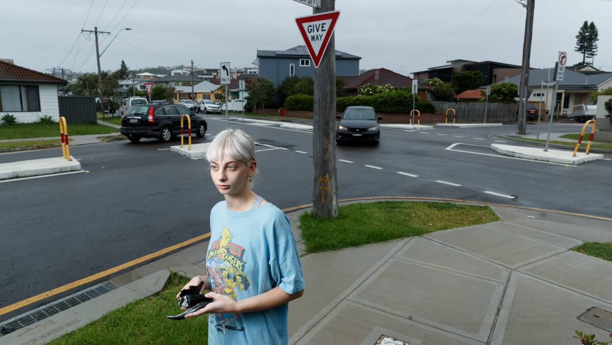 CALL FOR ACTION: Nearby resident Sophie Webber with a piece of debris from a recent collision at the intersection of Frederick and Helen streets at Merewether. She said there had been a growing number of crashes at the corner. Picture: Jonathan Carroll