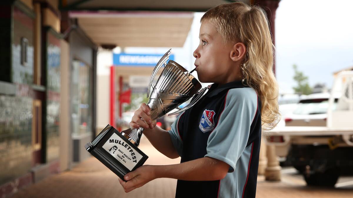STYLE: Laura Johnson's son Max, 6, taking a sip from the Best Mullet Of Them All trophy ahead of Mulletfest on February 29. Picture: Simone De Peak 