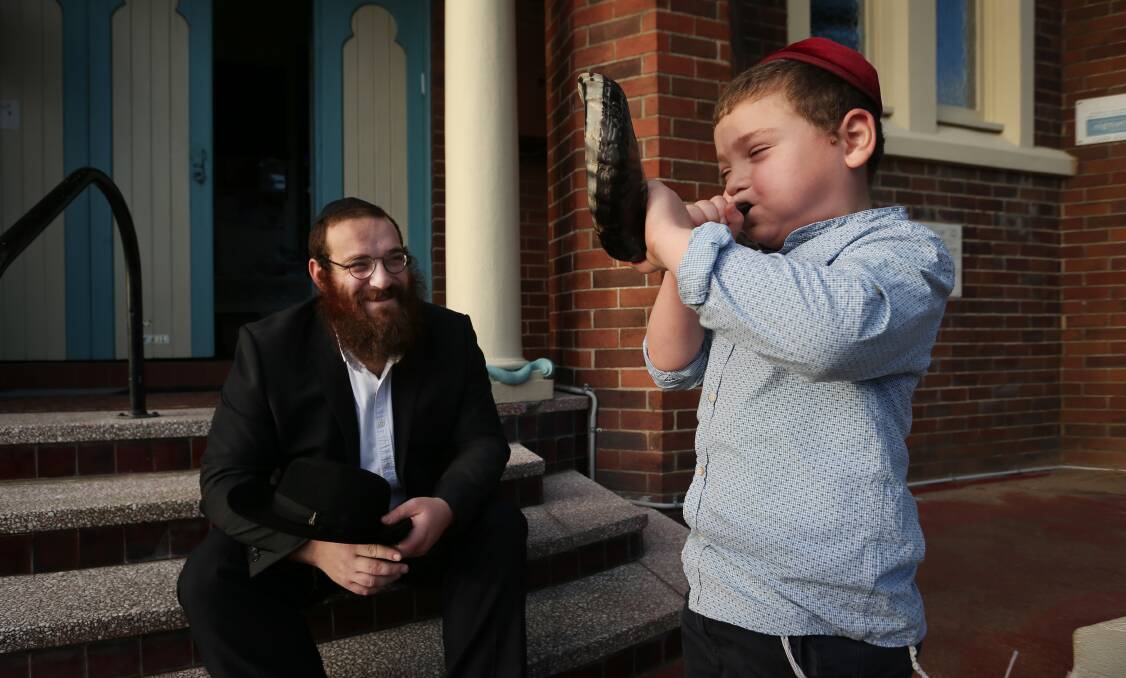 Rabbi Yossi Rodal with son Yitzchok blowing a shofar, which will be used during Jewish New Year this weekend. Picture: Simone De Peak