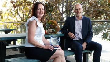 RECOGNITION: Hunter Hero winner Samantha Cross from Plastic Police with Hunter Water managing director Darren Cleary on a bench made from recycled plastic that was sourced through the Plastic Police program. Picture: Max Mason-Hubers