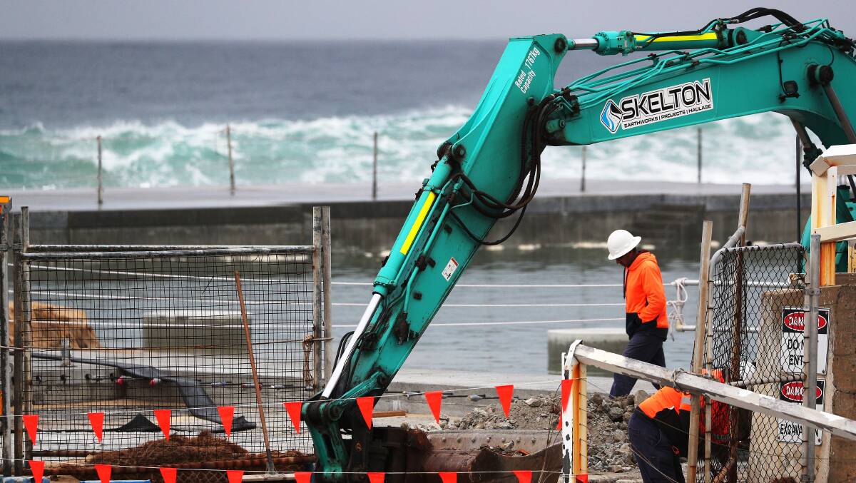 Works at the Newcastle Ocean Baths after heavy swells in July. Picture by Peter Lorimer