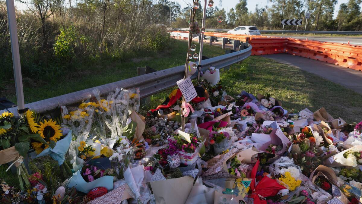 Floral tributes laid after the Greta bus crash on Wine Country Drive. Picture by Marina Neil