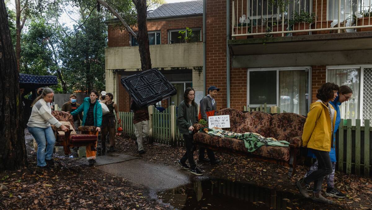 The squatters and their supporters moving furniture. Picture by Marina Neil