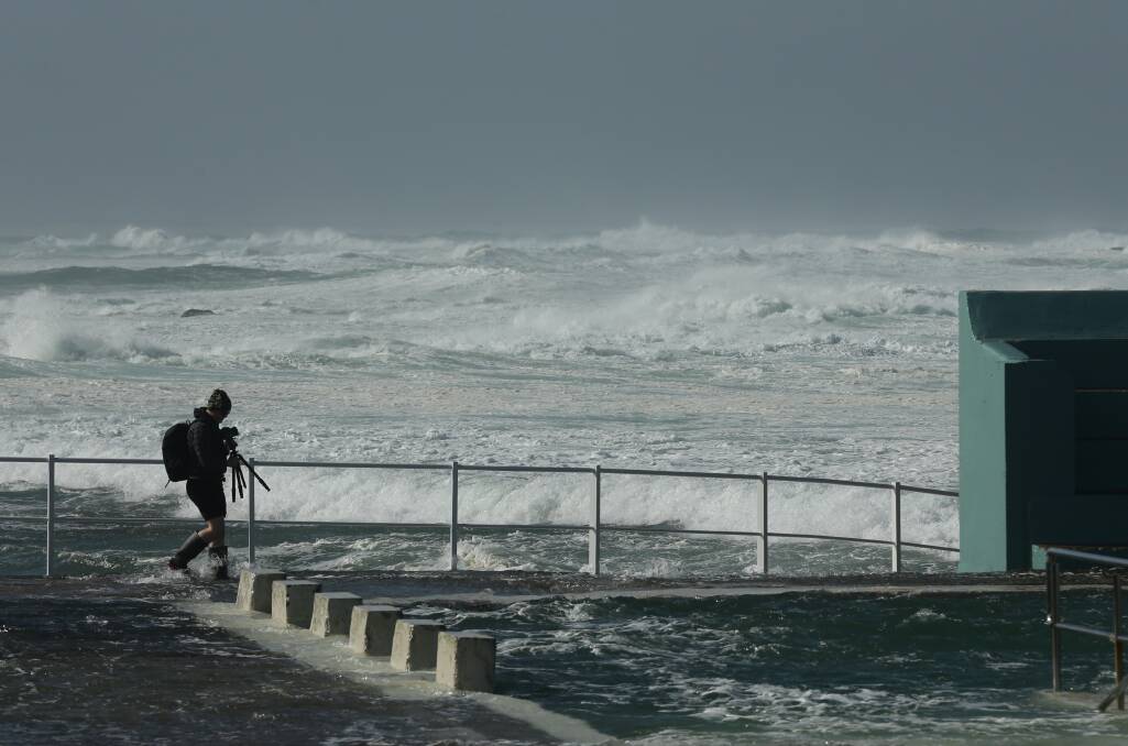 HAIRY: The Hunter's coastline was hit by wind gusts of up to 83km/h which produced powerful waves. Some brave storm watchers headed to Newcastle Ocean Baths to capture the action. Picture: Jonathan Carroll