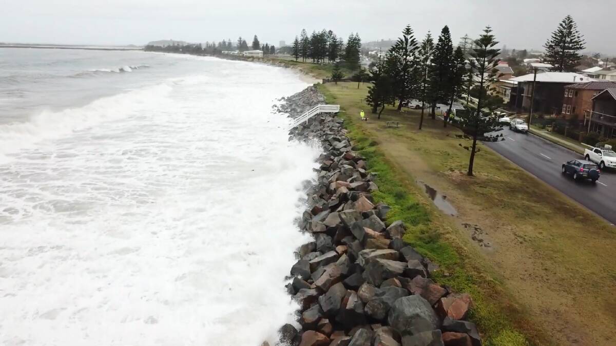 CLOSING IN: The sea smashes into the thin strip of land between the shore and Mitchell Street. Picture: Lucas Gresham