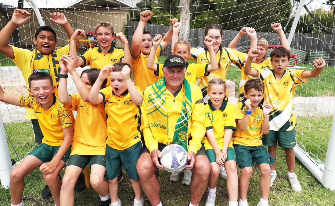 Holy Family Primary School Merewether Beach students with former Socceroo and 1974 World Cup player Col Curran on Friday. Picture by Peter Lorimer